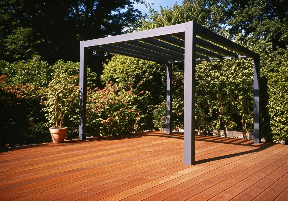 A modern aluminum pergola casting shadows on a wooden deck. 35mm stock photo