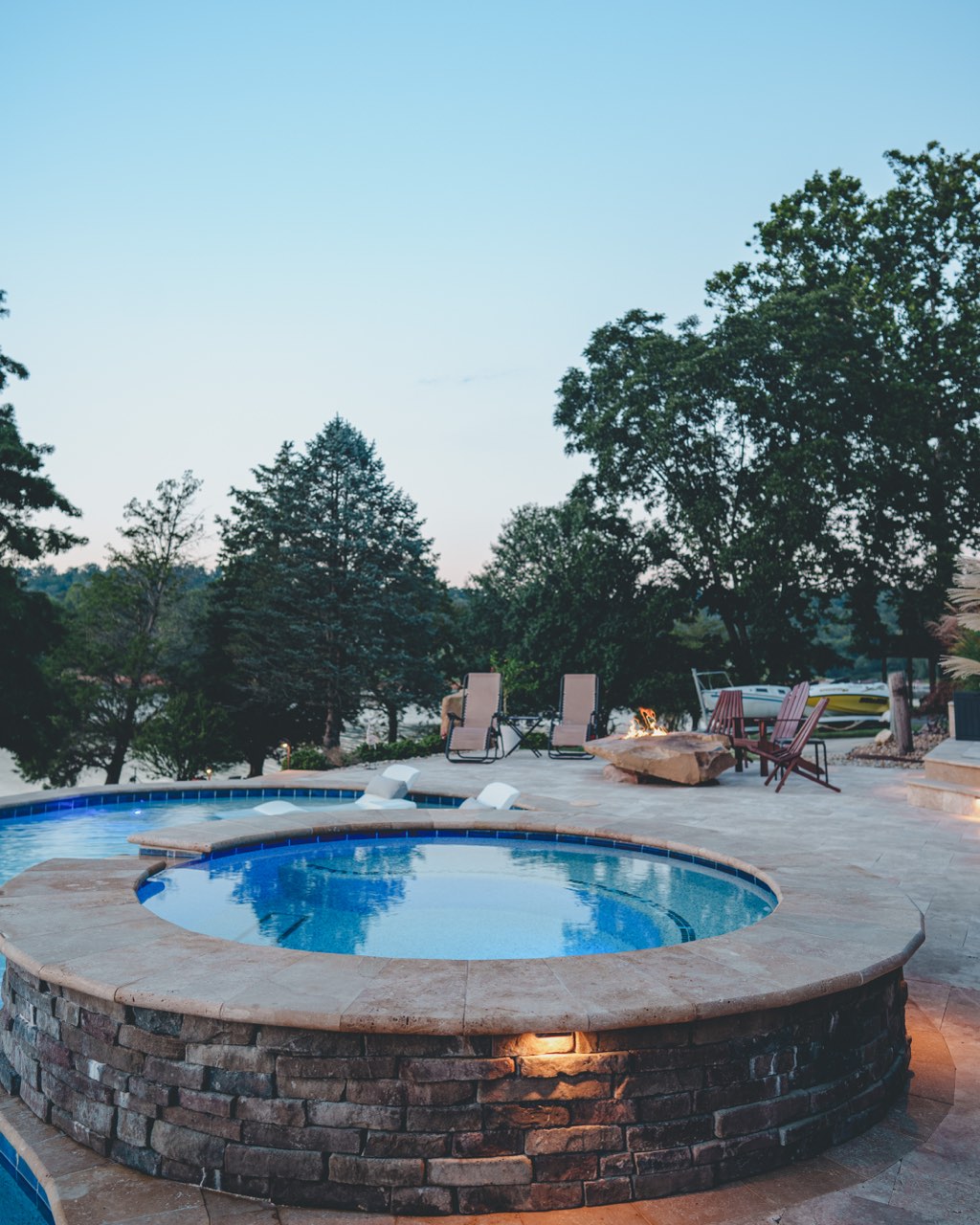 Raised Stone Spa & Pool With Lake at Dusk