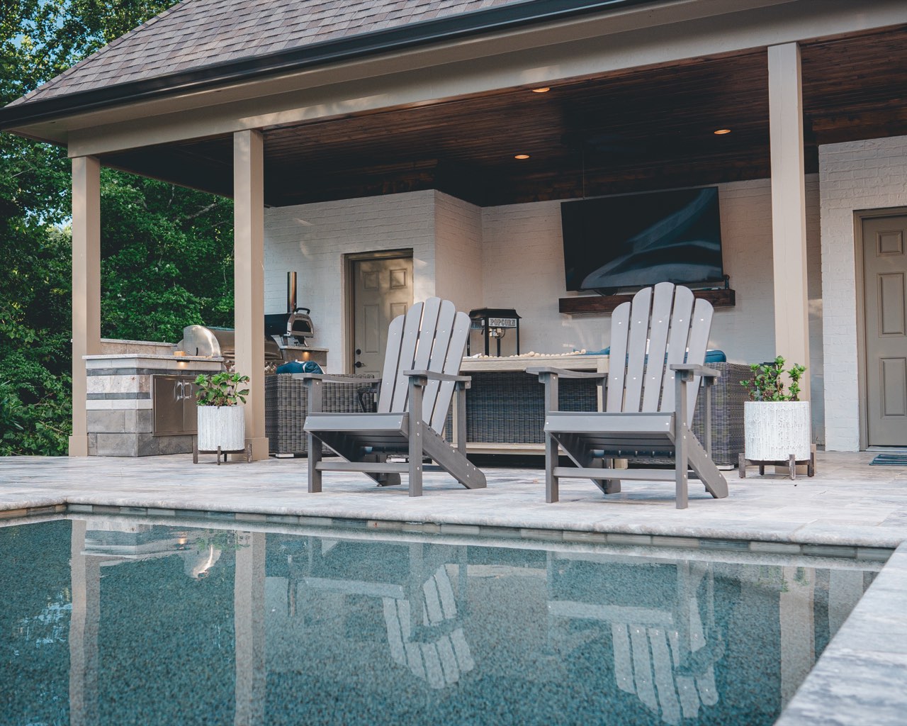 Twilight Poolside Pavilion With Outdoor Kitchen and Glowing Lights