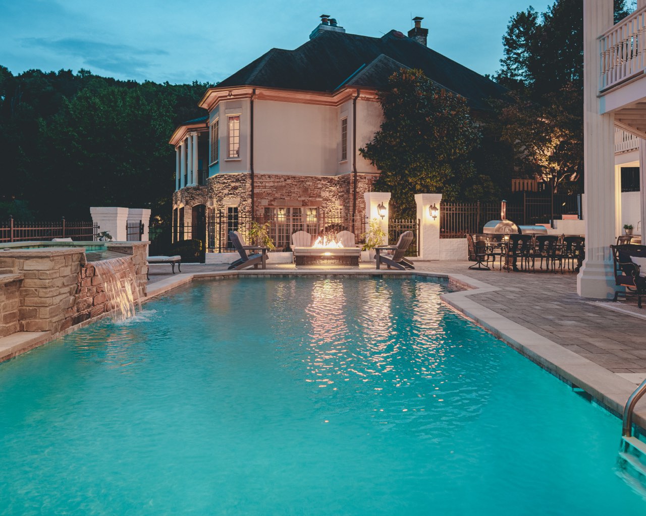 Gunite Pool With Stone Water Feature & Fire Bowls at Dusk
