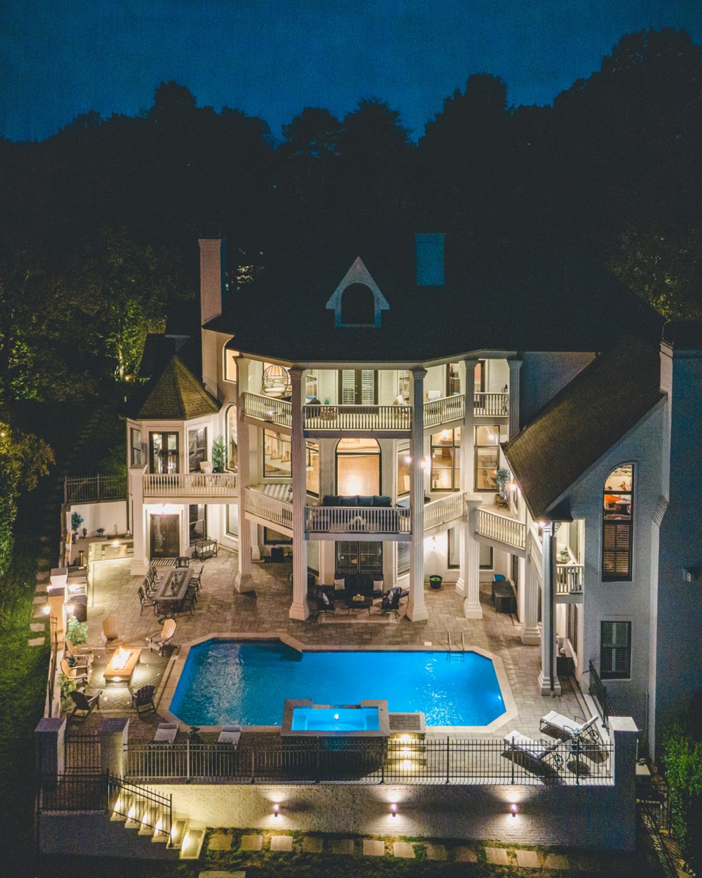 Twilight Estate Elevation With Illuminated Pool & Spa