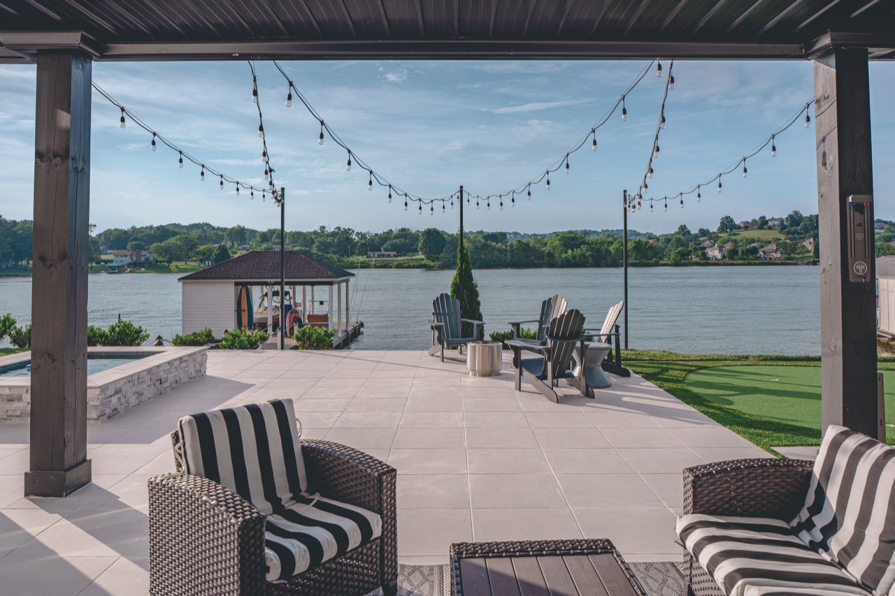 Covered Pergola Patio With String Lights Over Lake