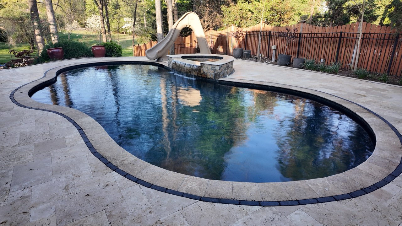 Freeform Gunite Pool With Raised Spa Waterfall and Travertine Paver Deck