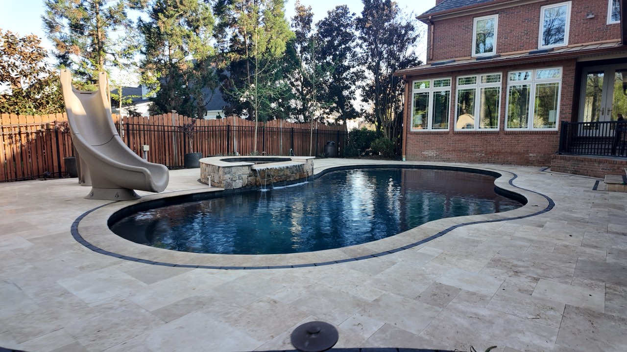 Freeform Gunite Pool With Slide, Raised Spa and Travertine Deck