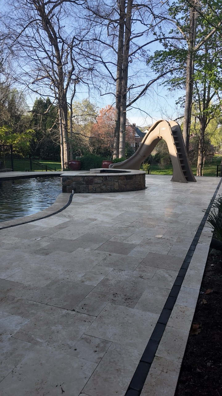 Travertine Pool Deck With Stone Fire Pit and Curved Slide