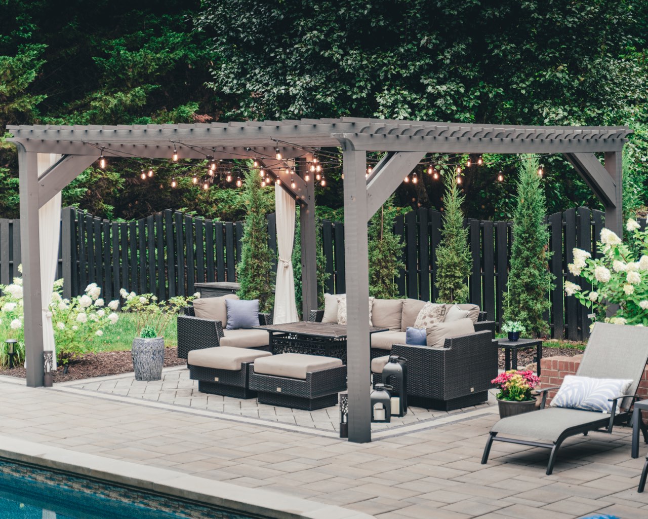 Poolside Pergola Lounge With String Lights And Loungers